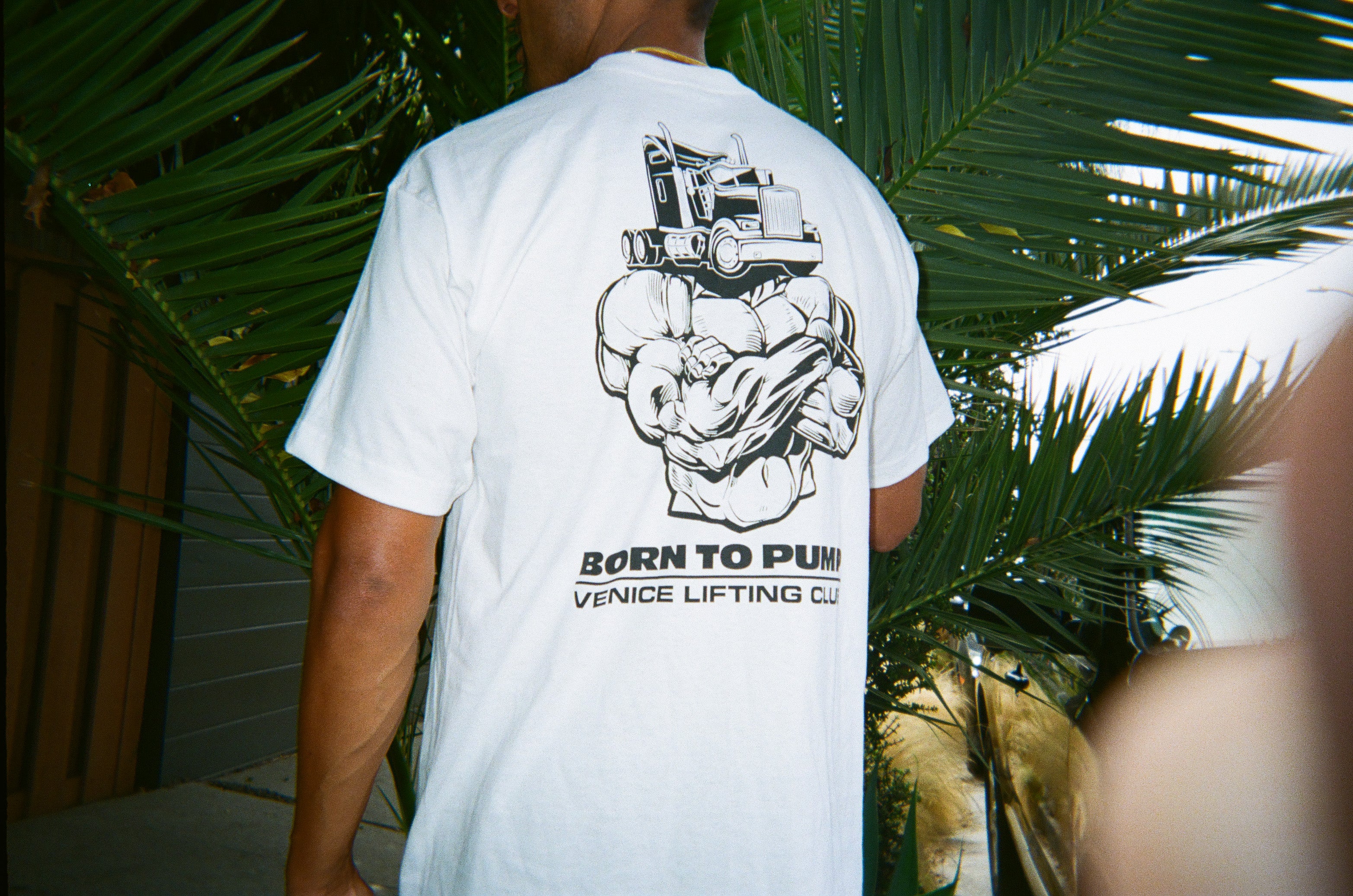 Venice Lifting Club, man wearing truck head t-shirt in front of palm tree